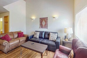 A living room with two sofas, a coffee table, and a lamp. - Cozy Condo with Moab Rim View, Wifi, Fireplace, Grill, and Seasonal Heated Pool (Moab)