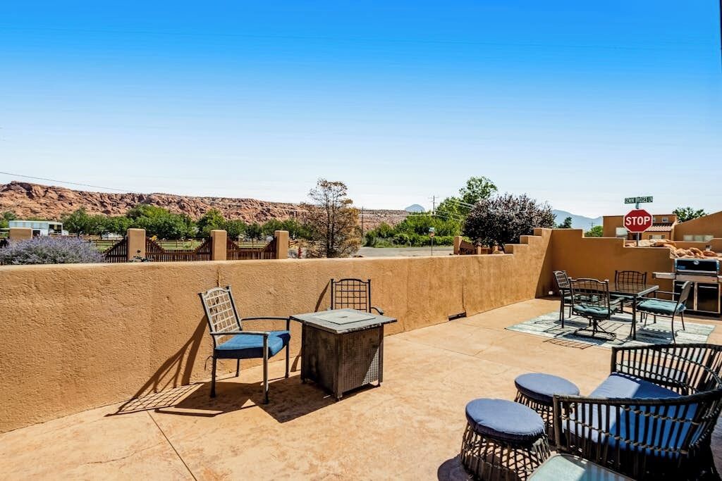 An outdoor patio with seating and a stop sign in the background.