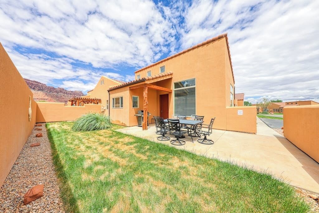 Propiedad residencial con patio, mobiliario exterior y vistas del paisaje circundante.
