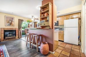 Eine Küche mit Holzausstattung, einem weißen Kühlschrank und einem Kamin.