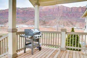 Un espacio al aire libre techado con una parrilla de barbacoa y vistas a formaciones rocosas rojas.
