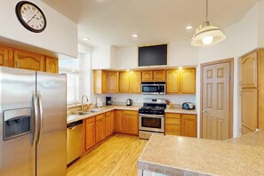 Una cocina moderna con armarios de madera, electrodomésticos de acero inoxidable y encimera de granito.