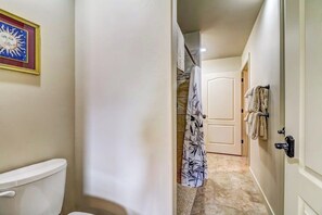 Ein Badezimmer mit Toilette, einer Duschvorhang und einem Handtuchhalter.