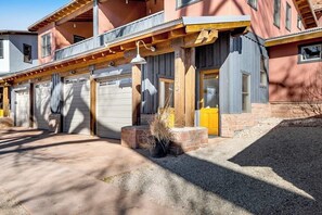En byggnad med flera våningar, en garageuppfart, en träveranda och en krukväxt.