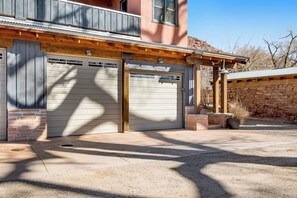 Ein zweistöckiges Gebäude mit Garage, Holzbalken und einer Steinwand.