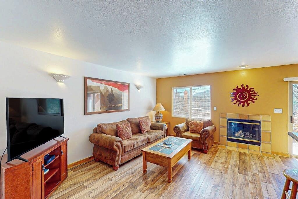 Ein Wohnzimmer mit Fernseher, Sofas, einem Couchtisch und einem Kamin.