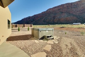 A hot tub in a courtyard with a mountain backdrop. - Tranquil 2BR Mountainview Rim View with Hot Tub (Moab)