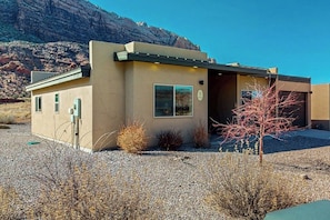 A modern building with a flat roof, a garage door, and a small entrance. - Tranquil 2BR Mountainview Rim View with Hot Tub (Moab)