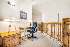A room with a desk, chair, lamp, and a wooden dresser. - Mountain View Home with Private Hot Tub & Patio - Close to Golf & Trails (Moab)