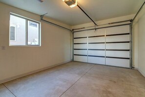 A garage with a sliding door, a window, and a ceiling light fixture. - Modern Desert Retreat in Moab with Mountain Views and Patio (Moab)