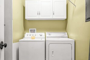 A laundry area with two washing machines and a cabinet above. - Dog Friendly Moab Mountain Escape with Provate Hot Tub, Fireplace, and Game Room (Moab)