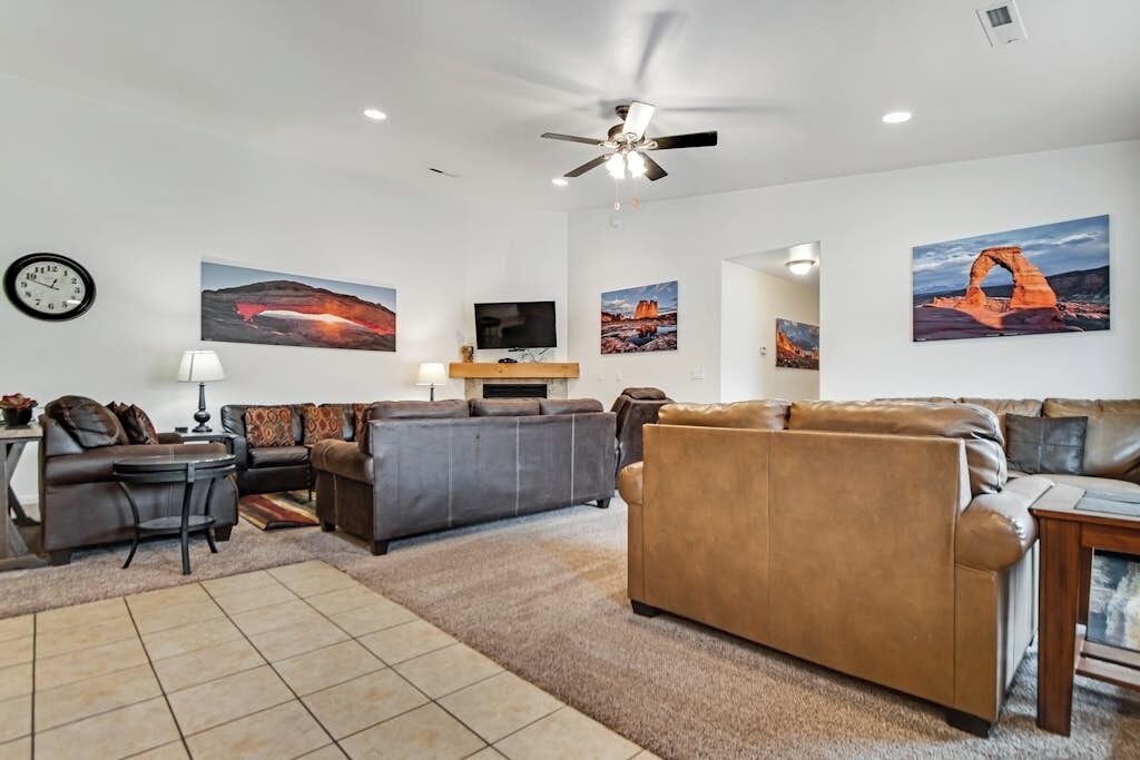 A living room with a sofa, a television, and artwork on the walls.