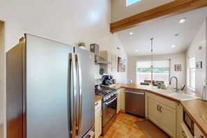 A kitchen with a stainless steel refrigerator, a stove, and a dishwasher. - Townhome in Rim Village with Red Rock Views, Community Pool & Hot Tub (Moab)