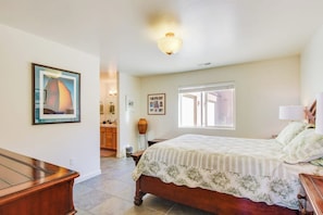 A bedroom with a bed, a desk, a window, and a door leading to a bathroom. - Lovely Mountain View Townhome with Shared Seasonal Hot Tub and Pool Near Downtown Moab (Moab)