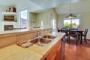 A kitchen with a large island, double sink, and a dining area with a table and chairs. - Lovely Mountain View Townhome with Shared Seasonal Hot Tub and Pool Near Downtown Moab (Moab)