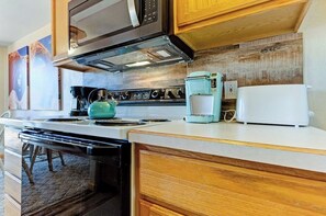 Eine Küche mit Herd, Kaffeemaschine und Toaster.