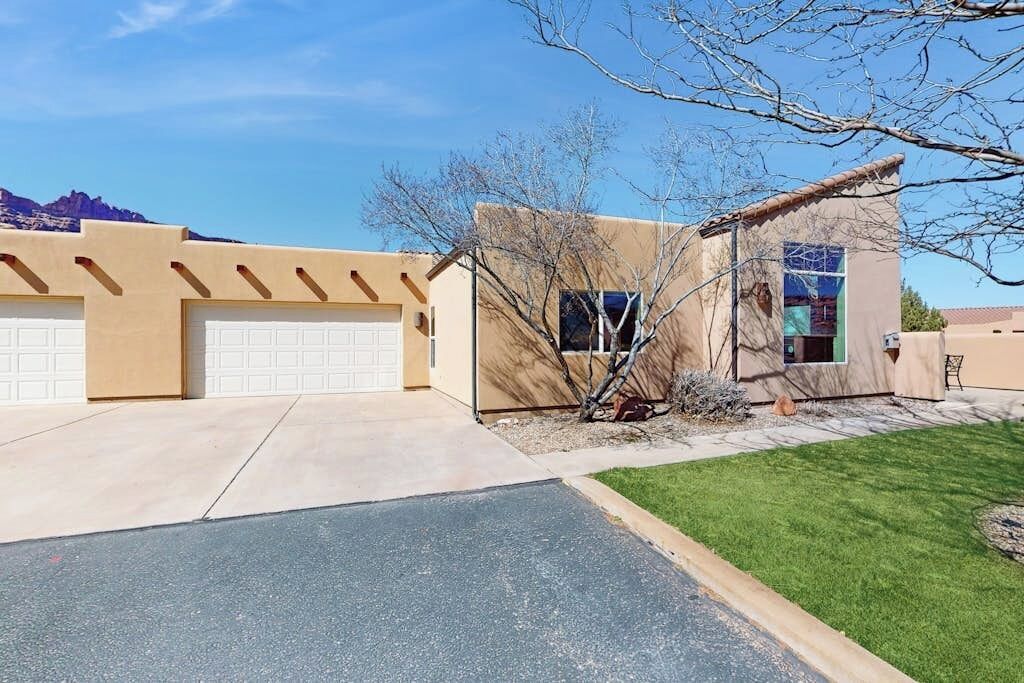 A residential property with a garage, a small attached structure with a window, and a well-maintained lawn.