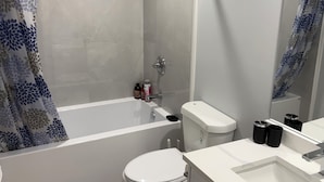 A modern bathroom with a shower, toilet, and sink. - Escape to a bright and spacious home tucked into a quiet, welcoming neighborhood (Edmonton)