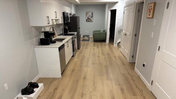 A modern kitchen with white cabinetry, a built-in oven, and a coffee maker. - Escape to a bright and spacious home tucked into a quiet, welcoming neighborhood (Edmonton)