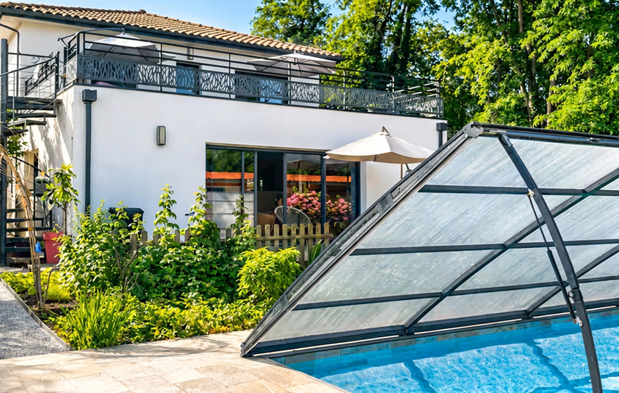 A modern house with a glass conservatory, a swimming pool, and a garden.