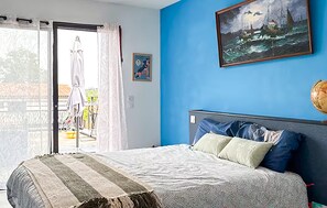 A bedroom with a bed, a painting, and a globe on the wall. - Luxurious home in Ondres with private swimming pool, can be inside or outside (Ondres)