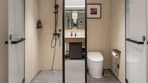 Un baño moderno con ducha, inodoro y lavamanos.