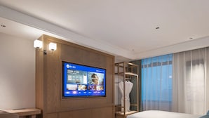 A hotel room with a bed, a desk, a television, and a wardrobe. - Manxin Hotel Wuhan (WUHAN)