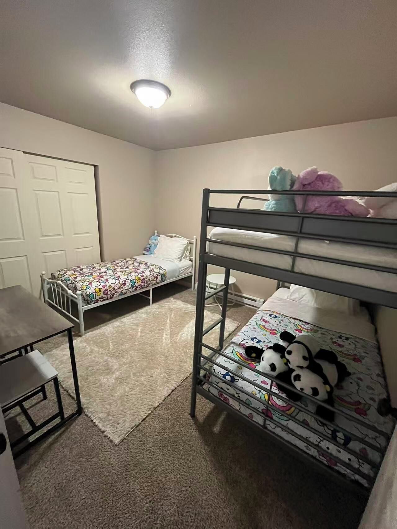 Ein Schlafzimmer mit Etagenbetten, einem Schreibtisch und einer Tür.