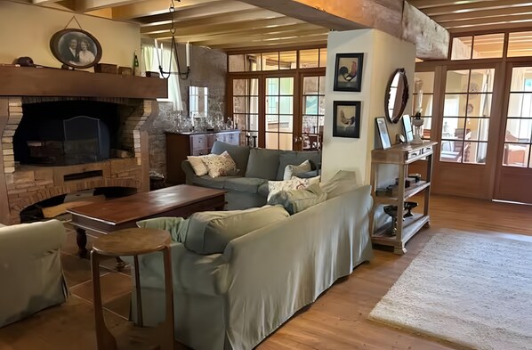 Un salon chaleureux avec une cheminée, un canapé, une table basse et une bibliothèque.