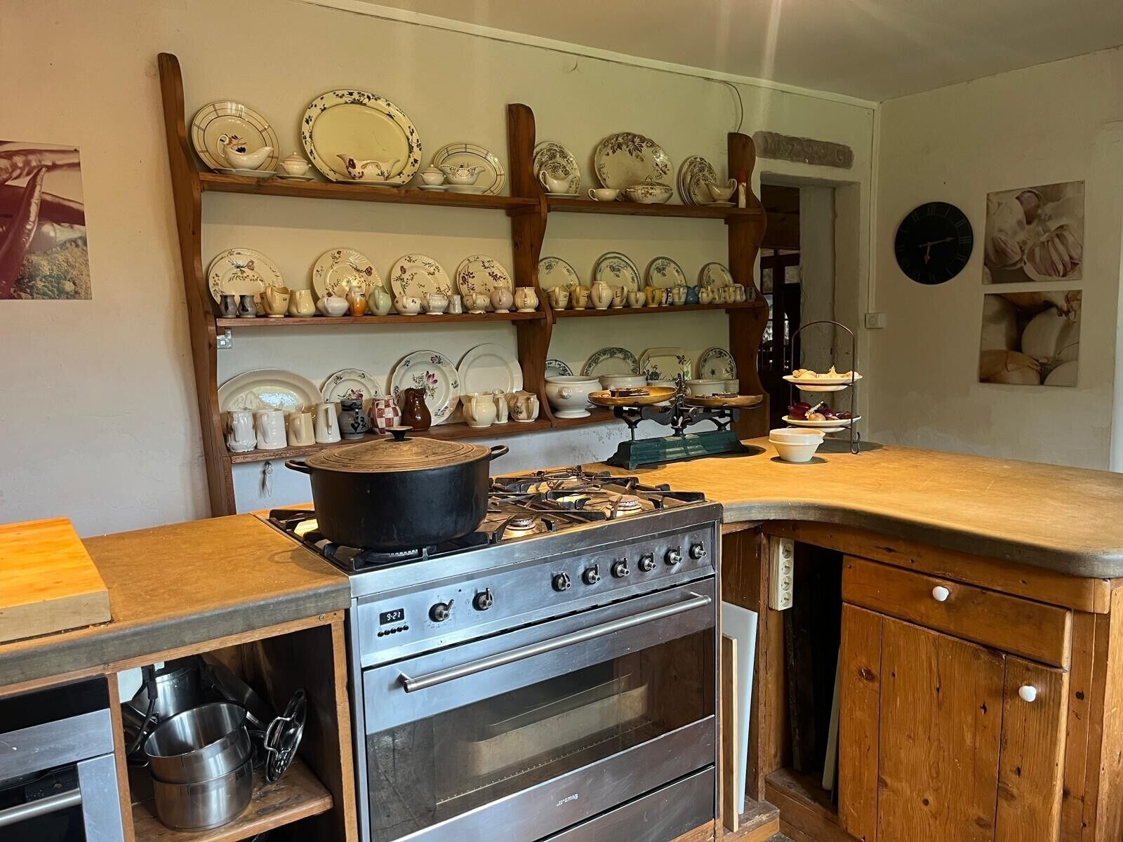 Une cuisine équipée d’une cuisinière, d’un four et d’étagères remplies de vaisselle.