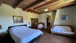 A bedroom with a large bed, a wooden ceiling, a sofa, and a painting on the wall. - Holiday Home "Harmangouty": Private Pool, 2.5 ha Grounds & Tranquil Forest Retreat (Raon-aux-Bois)