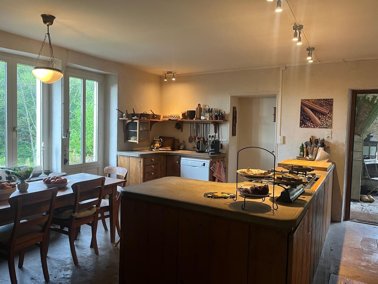 Une cuisine dotée d’un îlot central, de meubles en bois et d’une fenêtre donnant sur un espace verdoyant.