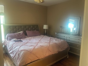 A bedroom with a bed, dresser, nightstand, lamp, and a ceiling fan. - Cozy 1-bedroom condo in lovely Slidell with AC WiFi and fitness room (Slidell)