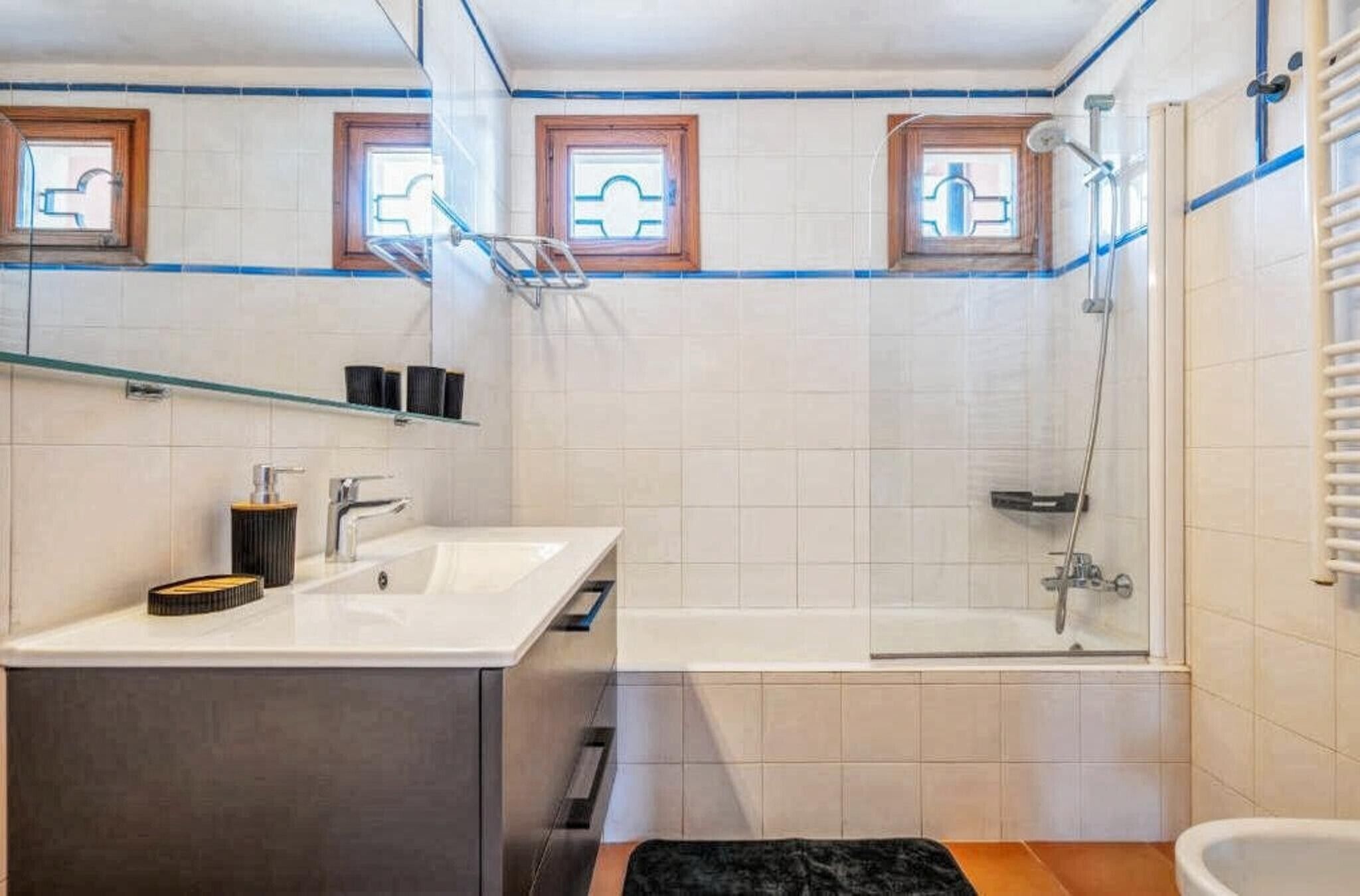 A bathroom with a shower, a sink, and a mirror.