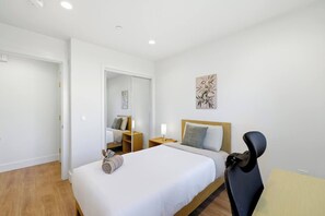 A hotel room with a bed, bedside tables, a chair, a mirror, and artwork on the wall. - Newly Renovated Luxury Home near Stanford & Techs (East Palo Alto)