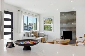 A modern living room with a fireplace, a sofa, and a coffee table. - Newly Renovated Luxury Home near Stanford & Techs (East Palo Alto)