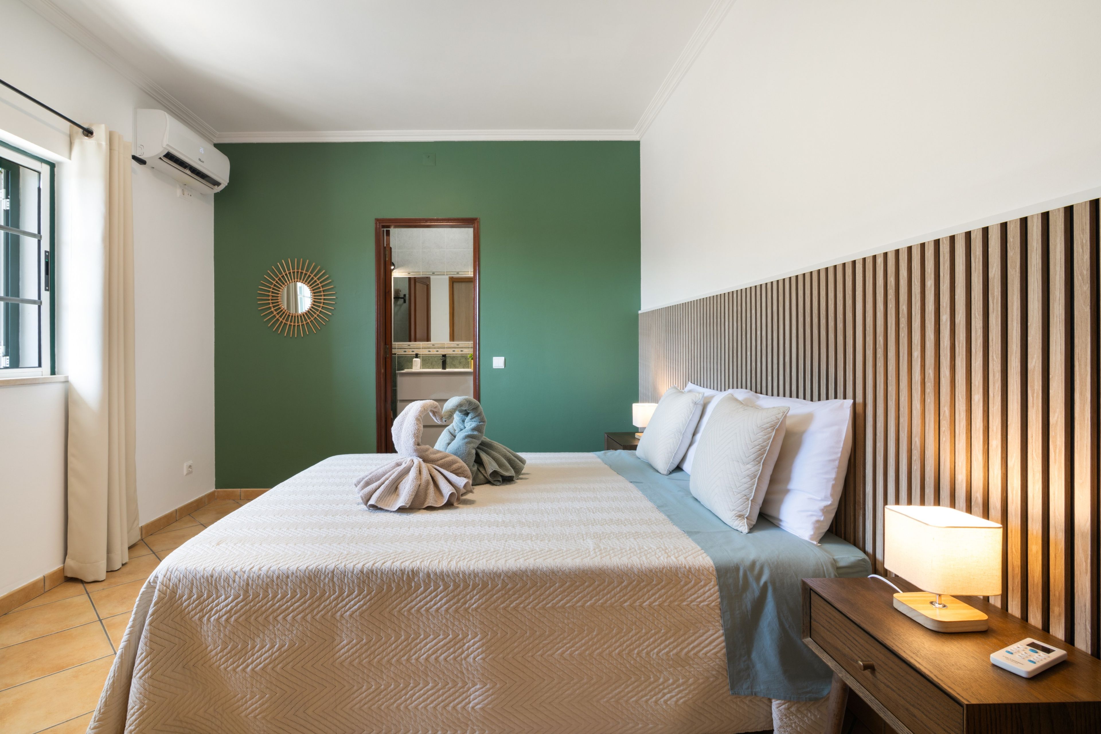 Ein Hotelzimmer mit einem Bett, einem Nachttisch, einer Lampe und einem Spiegel.