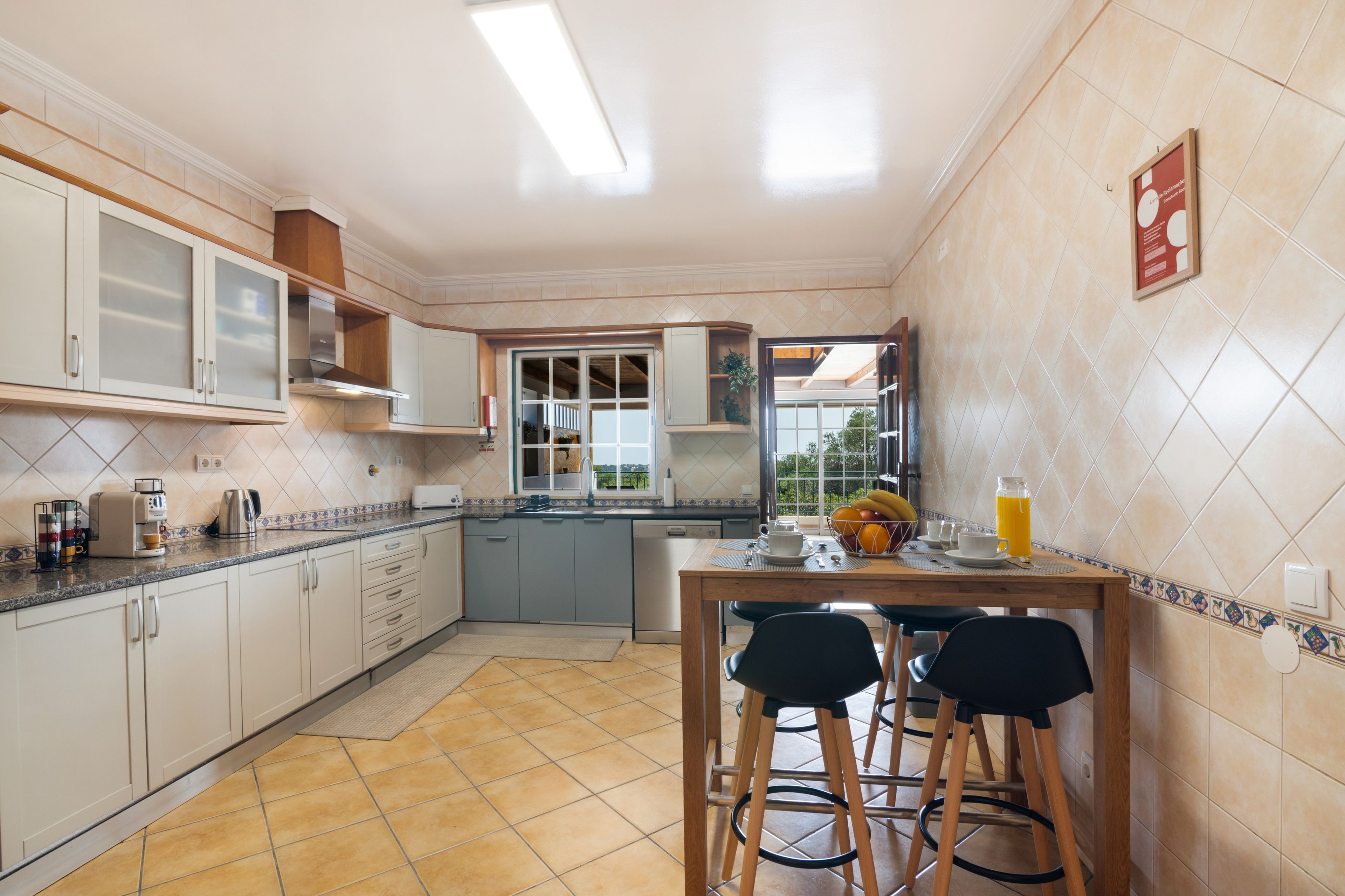 A kitchen with a dining area, a coffee machine, and a window with a view.