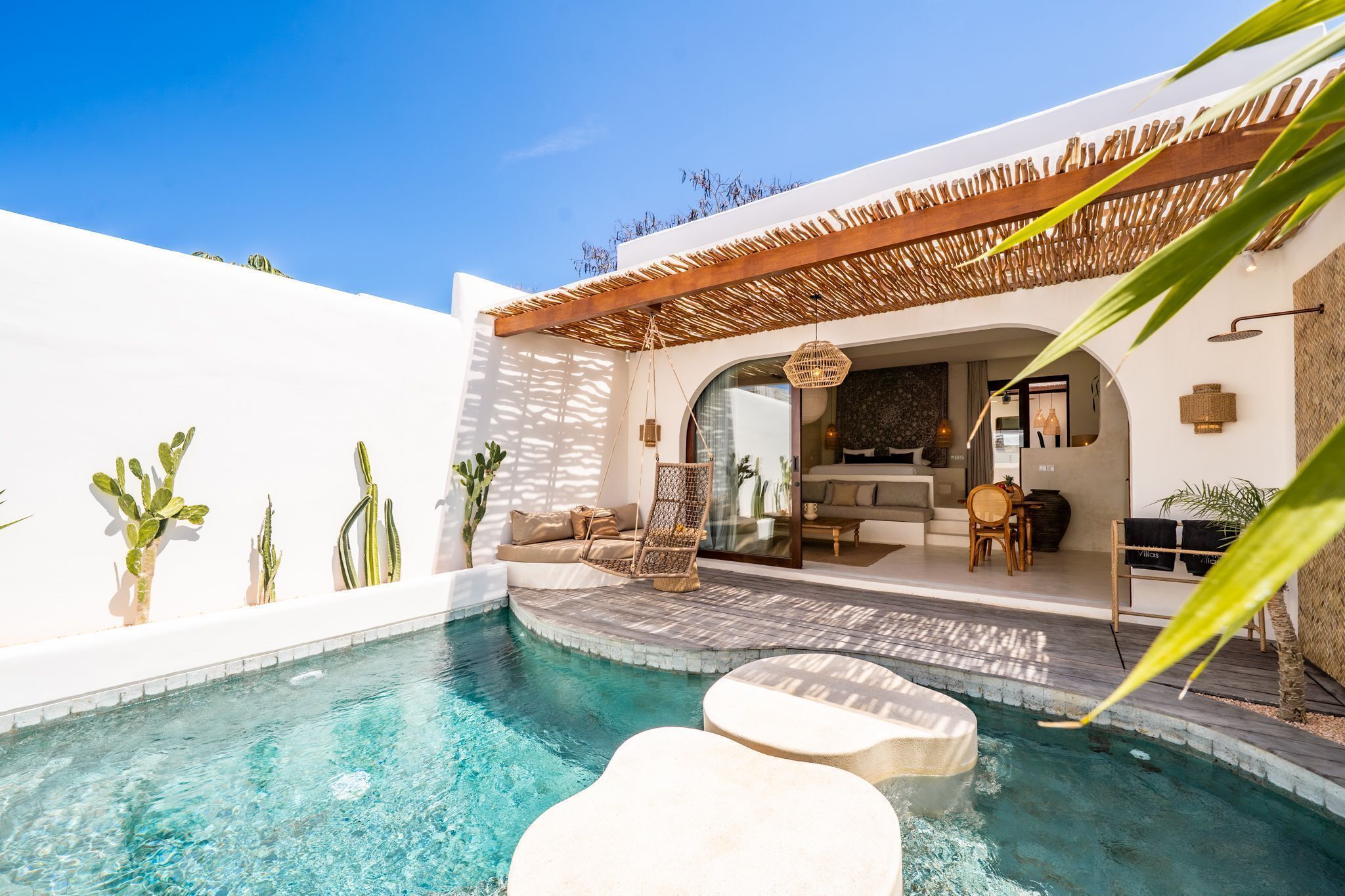A pool area with a seating arrangement and a covered patio.