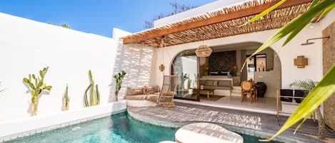 A pool area with a seating arrangement and a covered patio.
