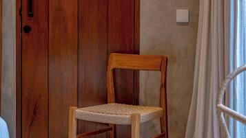 Una silla de madera con asiento tejido frente a una puerta de madera.