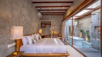 A modern bedroom with a large bed, bedside lamps, a view of an outdoor jacuzzi, and a wooden ceiling.