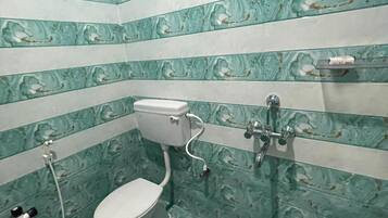A bathroom with a toilet, bidet, and shower. The walls have a marble-like pattern.