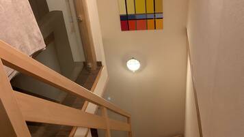 Eine Holztreppe mit Glastrennwand führt zu einer Zwischenebene.
