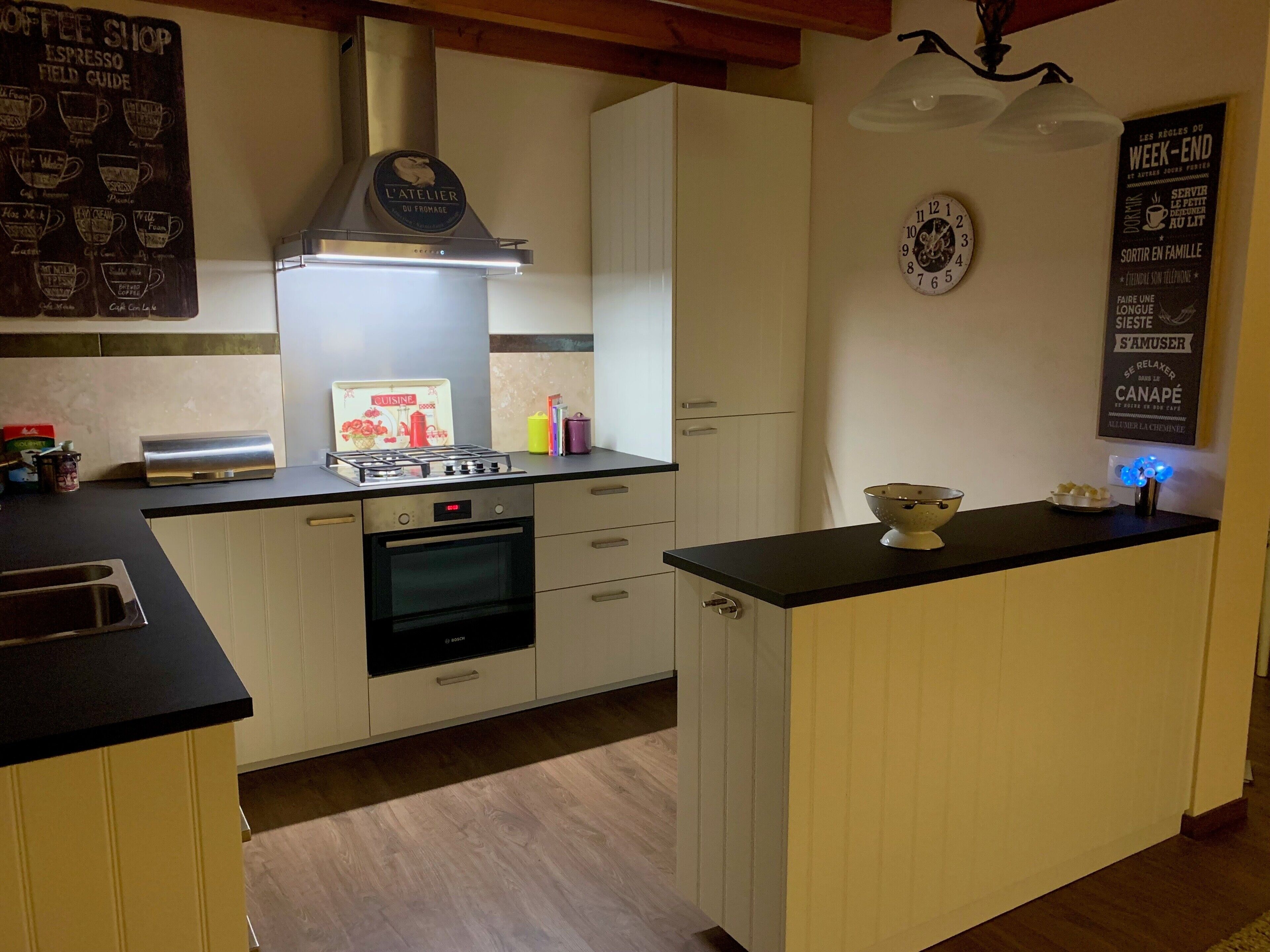 Eine Küche mit einem Bosch-Backofen, einem Gasherd und einem Schild für ein Café an der Wand.