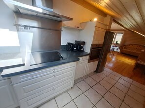 A modern kitchen with a built-in stove, oven, and coffee maker.