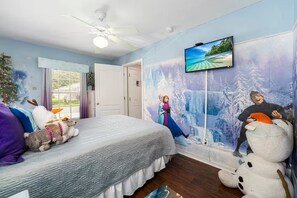 A bedroom with a bed, a ceiling fan, a TV, and a mural. - Our Happy Place! FREE Pool Heat (Davenport)
