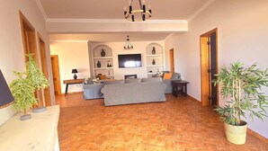 A living room with a sofa set, a television, and a decorative plant. - Villa 'Casas Do Monte I - T3' with Shared Pool, Private Terrace and Wi-Fi (Moinhos de vento)