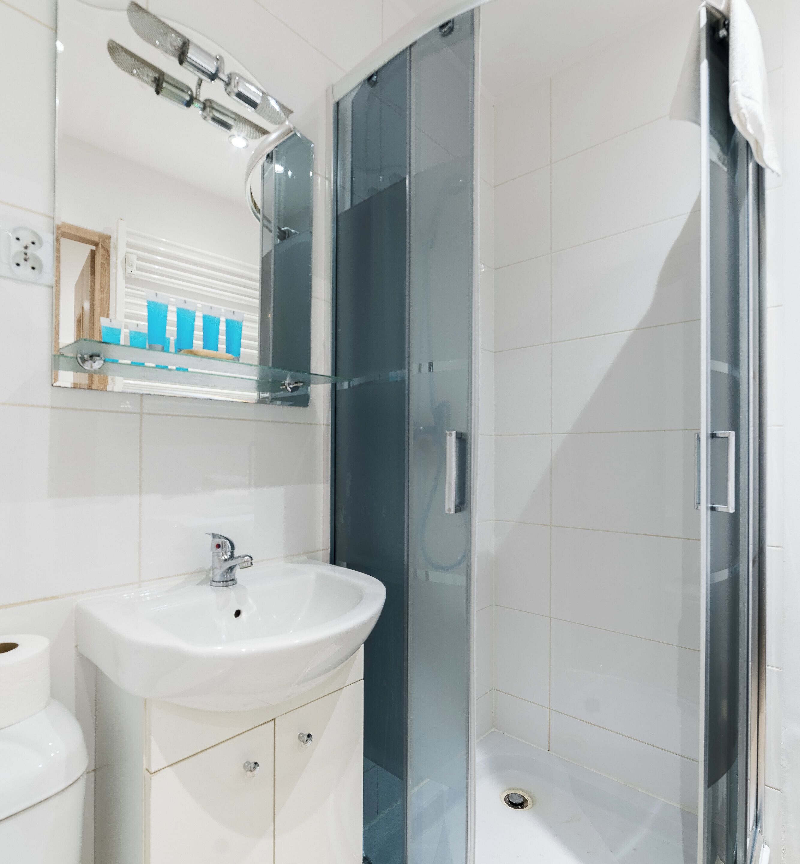 Ein modernes Badezimmer mit Waschbecken, Spiegel und Duschkabine aus Glas.