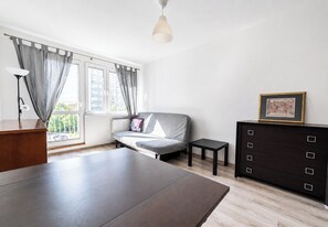 Ein modernes Zimmer mit einem Bett, einem Schreibtisch, einer Kommode und einem Fenster mit Vorhängen.